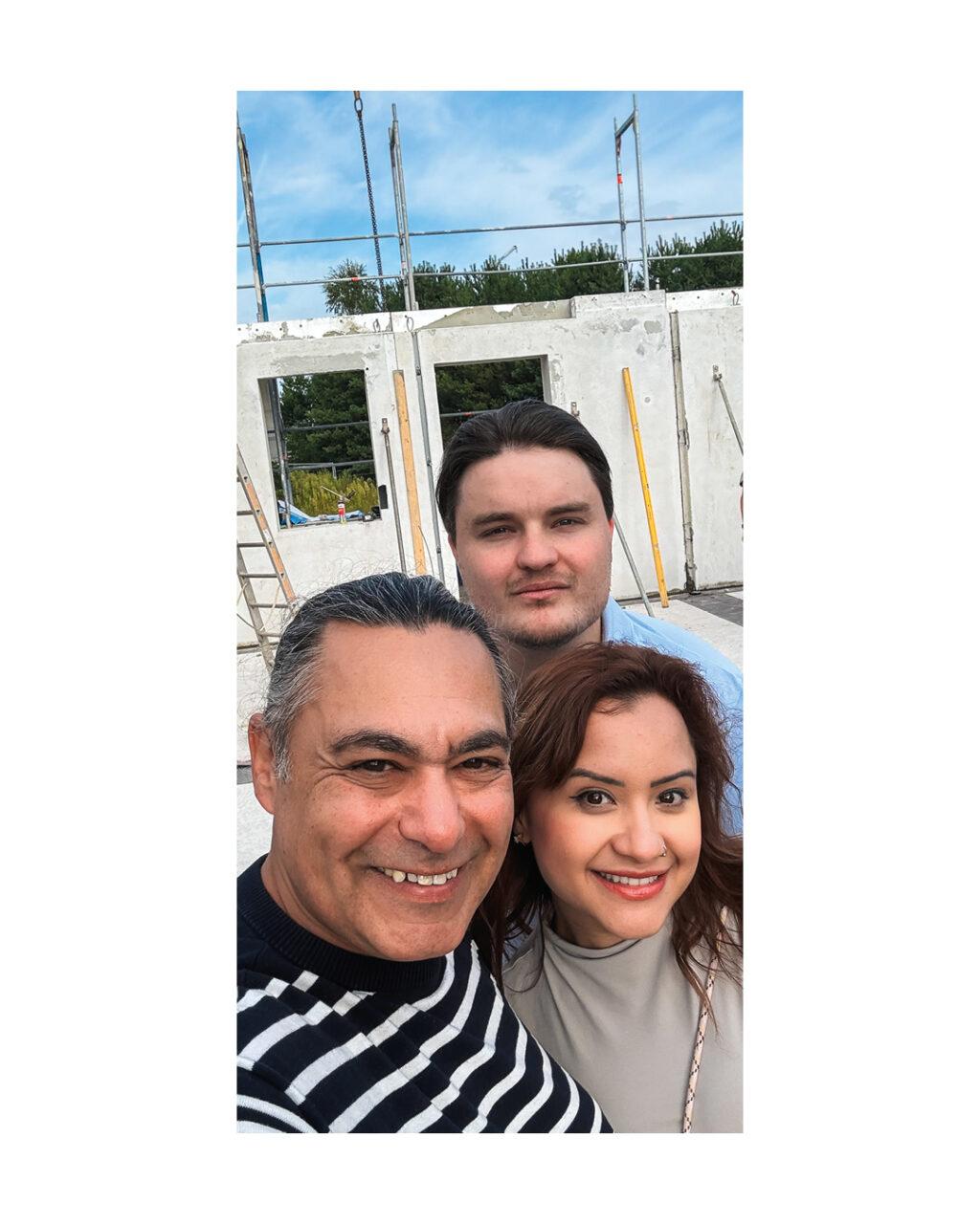 Selfie der Bauherrenfamilie (drei Personen) auf der Baustelle. Zeigt die Freude und das Engagement der Familie während der Hausbauphase und unterstreicht die persönliche Betreuung beim Bauträger.