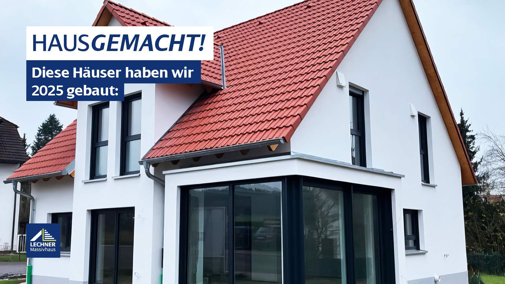 Modernes Lechner Massivhaus mit rotem Satteldach, weißer Fassade und markantem Glas-Eck-Erker – Rückblick auf realisierte Bauprojekte 2025 und Inspiration für den Hausbau 2026.