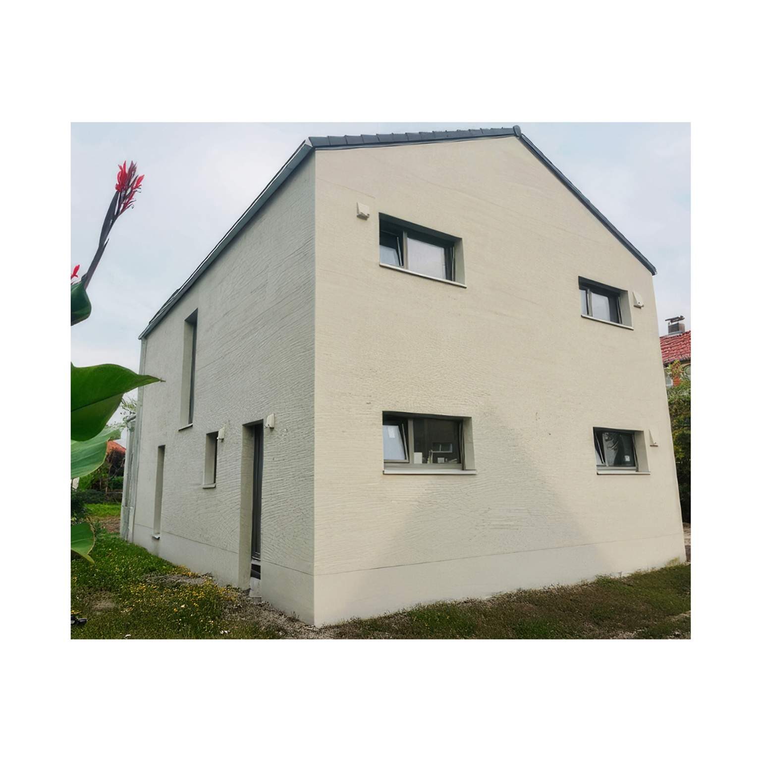 Schlichtes, elegantes Massivhaus mit beiger Putzfassade und symmetrischer Fensteranordnung.