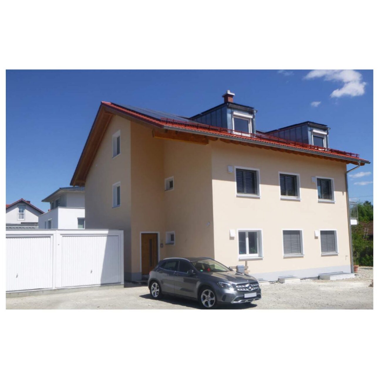 Großzügiges Mehrfamilienhaus oder Mehrgenerationenhaus mit zwei Dachgauben und integrierter Garage in hochwertiger Massivbauweise.